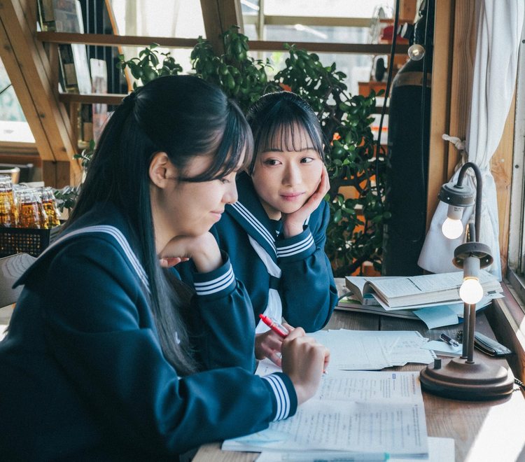 机に向かう2人の高校生